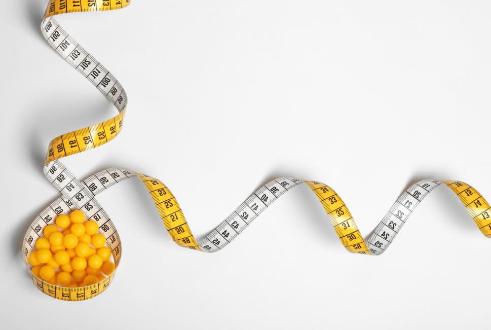 vitamins and tape measure in the table
